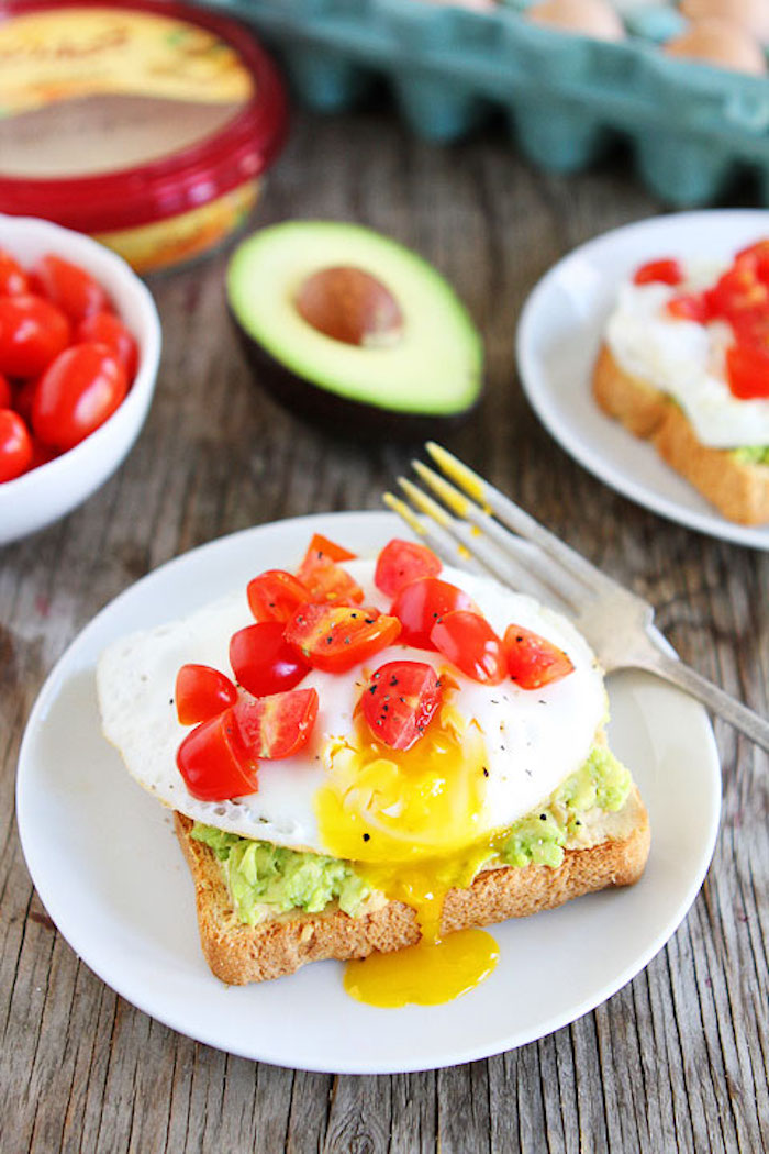 kalorienarme rezepte zum frühstücken, brotscheibe mit ei, cherry tomaten und avocadopüree