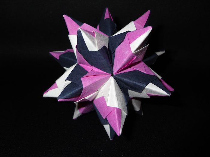 ein großer bascetta stern mit violetten, schwarzen und weißen strahlen aus papier, origami falten, basteln mit papier