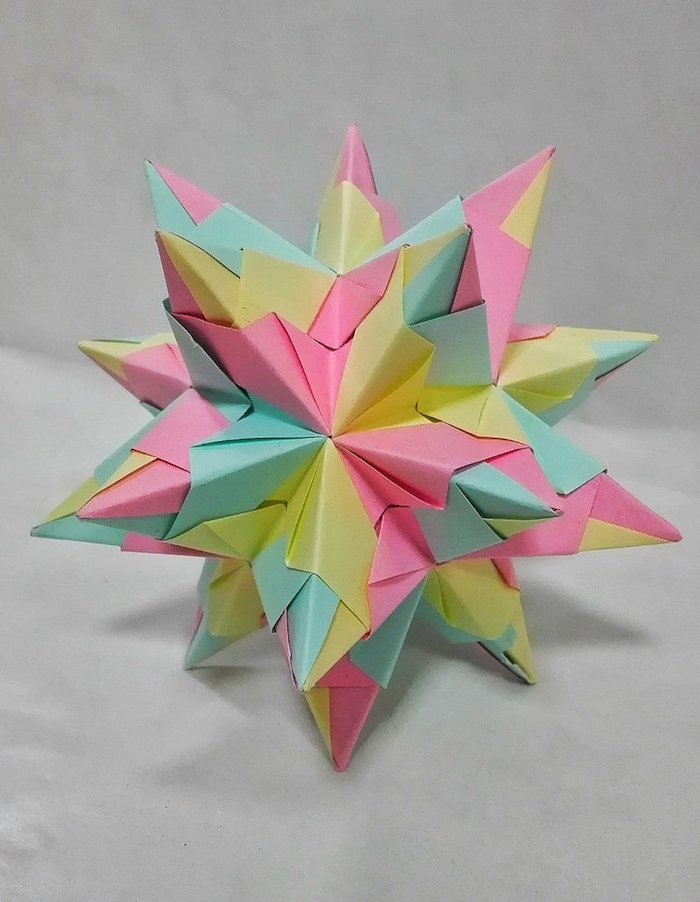 ein großer bunter bascetta stern mit grünen, violetten und gelben strahlen aus papier, origami sterne falten 