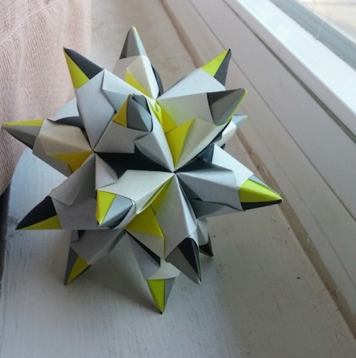 ein fenster und ein großer grauer origami stern, bascetta stern basteln, ein bascetta stern mit grauen und grünen strahlen aus papier