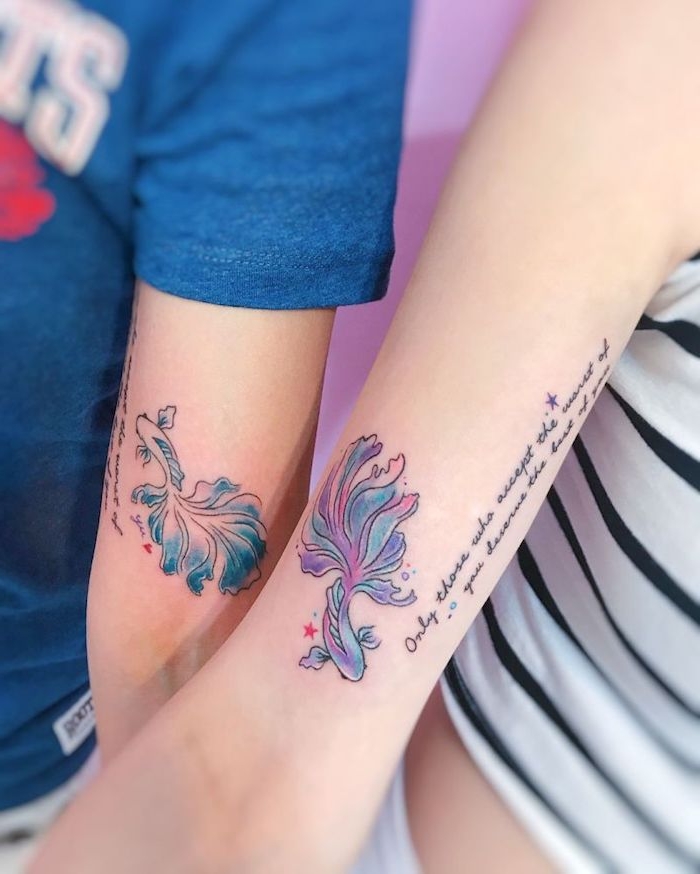 junge menschen mit händen mit zwei bunten watarcolor tattoos für paare mit zwei kleinen violetten und blauen fischen