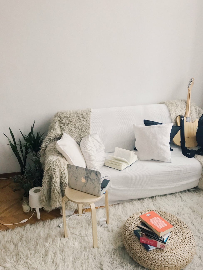 Wohnzimmer Weiß Grau, mit einem weißen Sofa und verschiedene Kissen