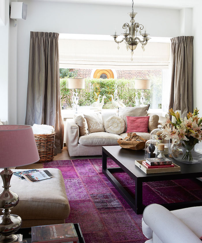 ein wohnzimmer einrichten mit weißen und pinken lampen und mit einem violetten teppuc und mit weißen sofas und einem kleinen schwarzen tisch aus holz und mit einer vase mit blumen, wohnzimmer modern, farbe aubergine kombinieren