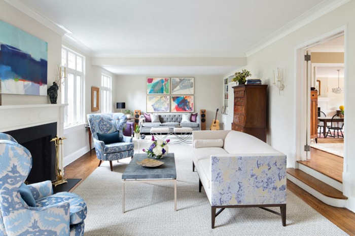 zwei blaue Sessel, ein Sofa mit kleinen blauen Motiven, ein weißer Teppich, ein kleiner Couchtisch, Dekoideen Wohnzimmer