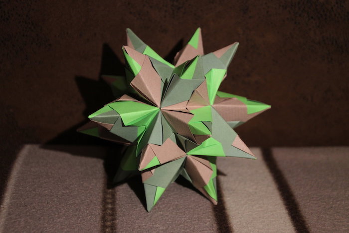eine braune wand und eine braune decke, einen grünen origami stern falten, ein bascetta stern mit braunen und grünen strahlen aus papier