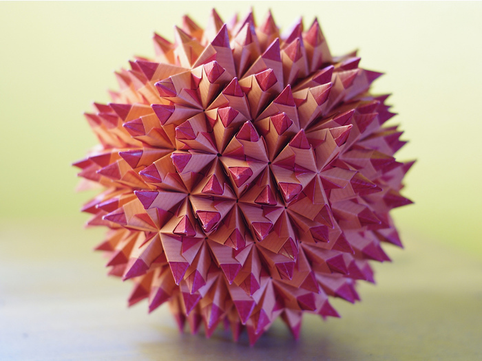 eine große pinke kugel mit vielen kleinen pinken und violetten strahlen aus papier, origami falten anleitung, basteln mit papier