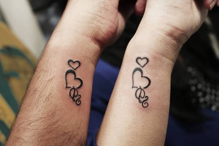 ein man und eine frau und zwei hände mit kleinen schwarzen herzen tattoos für paare, tattoos am handgelenk