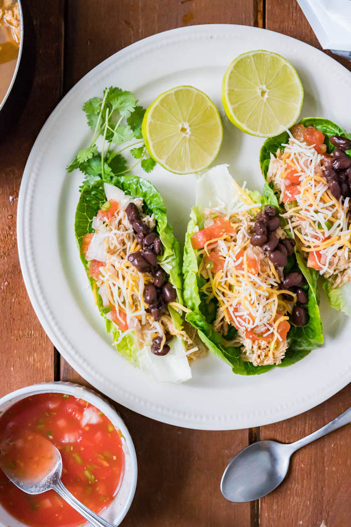 gesundes abendessen, tacos aus grünem salat gefüllt mit geschnittenen tomaten, bohnen und käse