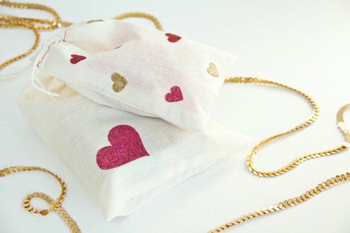 Geschenktüten basteln, rosa und goldene Dekorationen in der Form von Herz