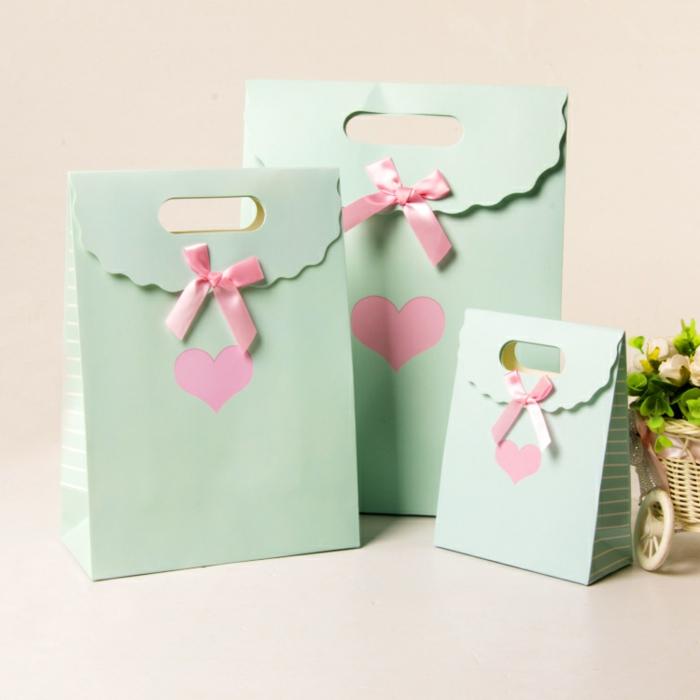 grüne Papiertüten, rosa Herzen in der Mitte, Geschenktüte falten mit rosa Schleifen