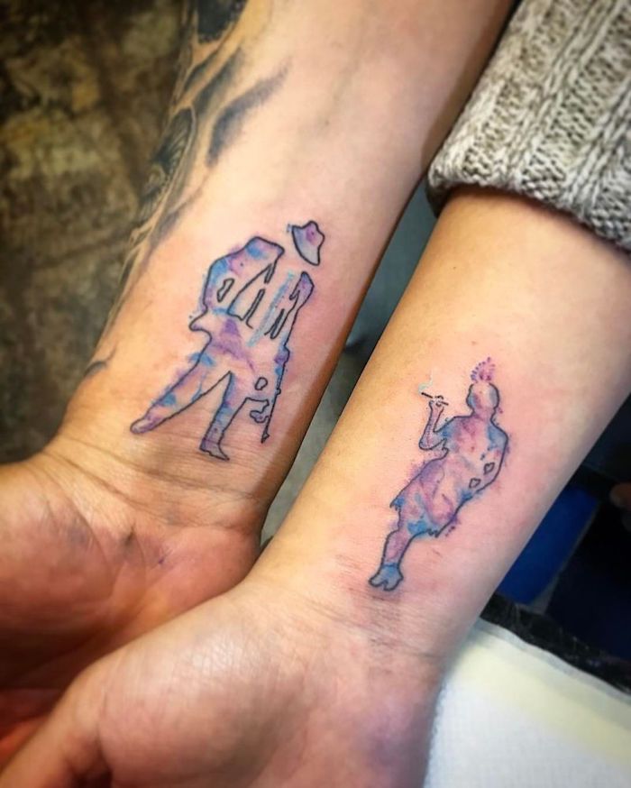 zwei hände mit kleinen watercolor tattoos mit einem mann und einer rauchender frau mit blauen schuhen, kleine partnertattoos am handgelenk