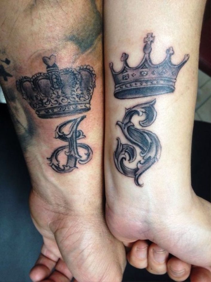 tattoos für paare, zwei hände mit großen schwarzen tattoos mit kronen am handgelenk, ein partnertattoo