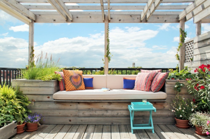 sitzecke balkon eine bank aus holz oder paletten selber machen, frisch und schön wirken lassen mit bunten kissen und vielen pflanzen, kleiner stuhl türkis farbe