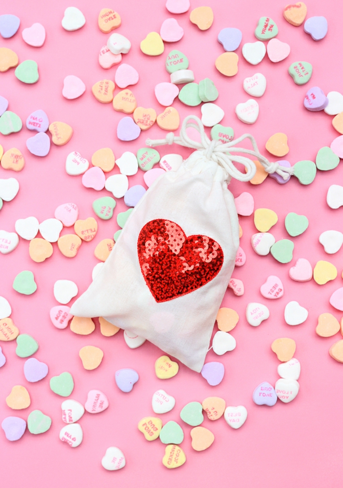 eine kleine weiße Tüte mit einem großen Herz aus Bügelperlen, kleine Geschenktüten voller Süßigkeiten