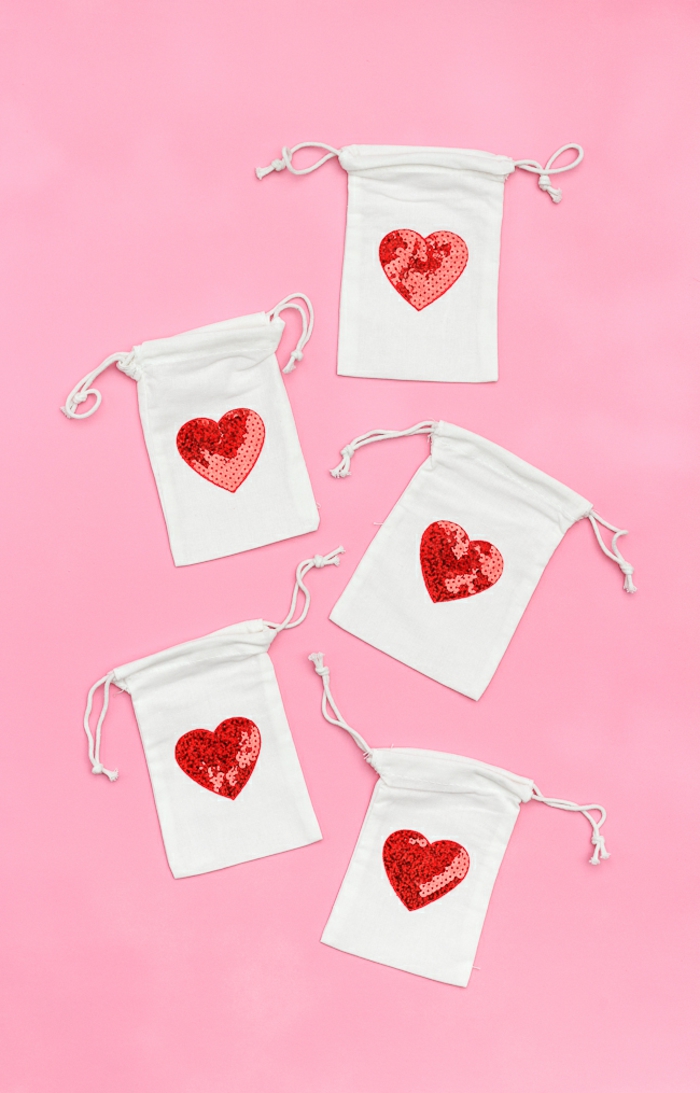 fünf kleine Geschenktüte in weißer Farbe mit roten Herzen in der Mitte