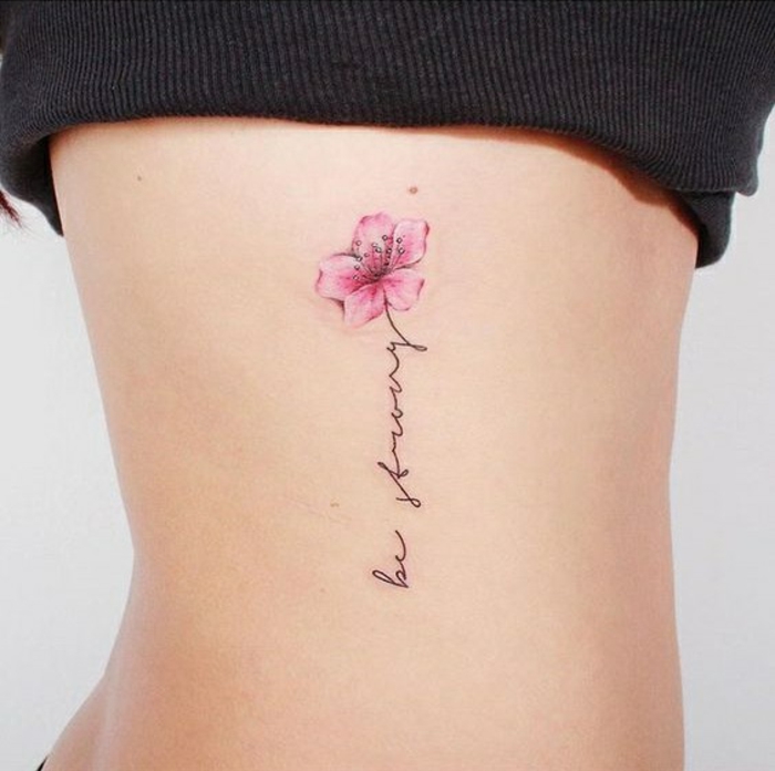tattoo blumen und aufschrifte zum inspirieren, tattoo bild und zitat zusammen, rosarote blume und schöner schwarzer schrift