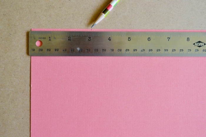 Geschenktüten selber basteln, eine Linie und Papier in rosa Farbe beim Messen