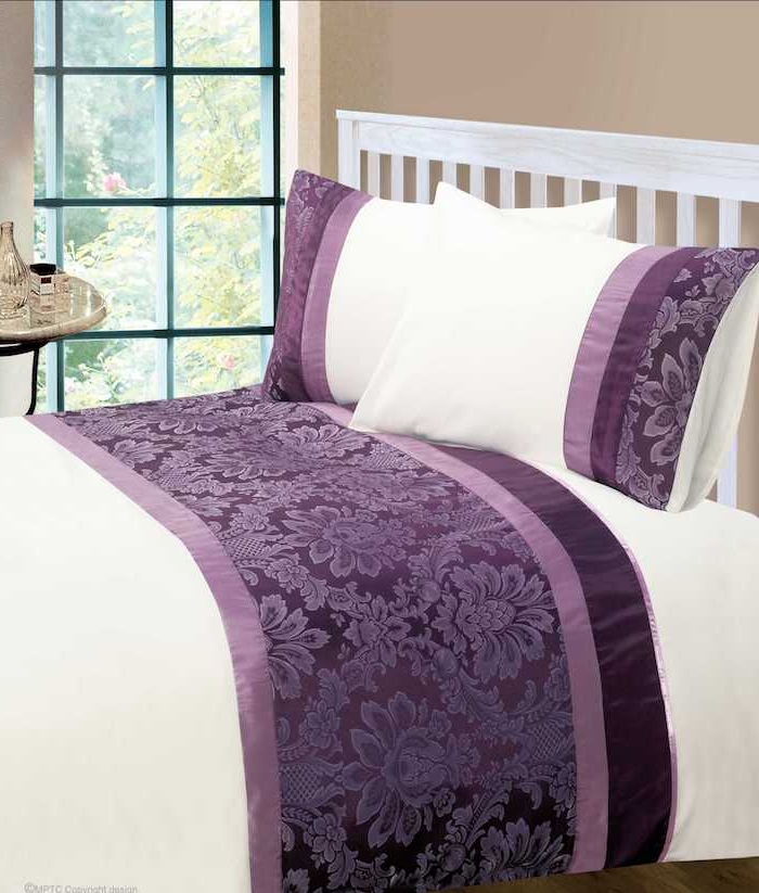 ein schlafzimmer mit einem großen bett mit einer violetten decke und mit weißen und violetten kissen und einem großen fenster, schlafzimmer aubergine farbe