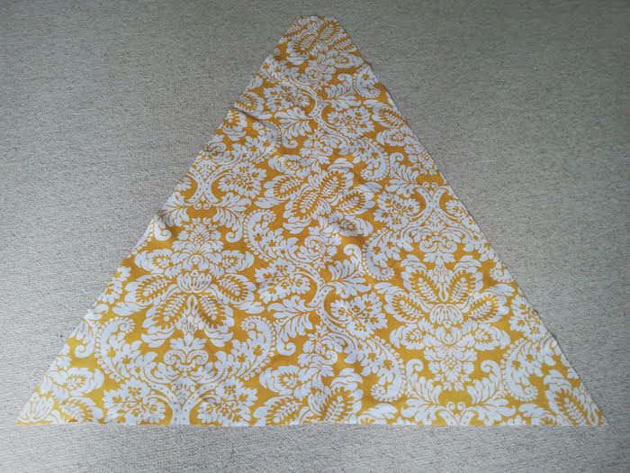 ein großes gelbes dreieck aus einem gelben stoff und mit vielen weißen blumen und blättern und ein grauer teppich, eine diy anleitung, ein spielzelt tipi selber bauen