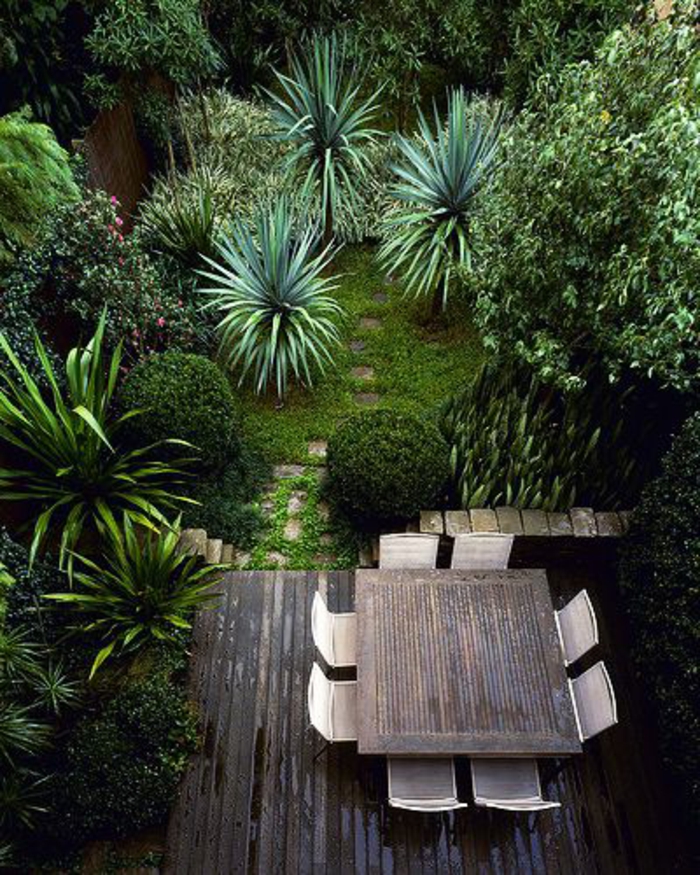 moderne stilphase der englischen kunst, viele grüne pflanzen zu hause, büsche, kleine palmen, sitzecke mit tisch und stühlen
