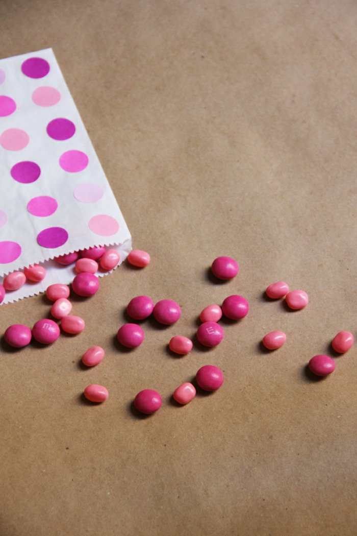 Papiertüten falten, rosa Papiertüte mit Punkten dekoriert, Tütte voller Bonbons
