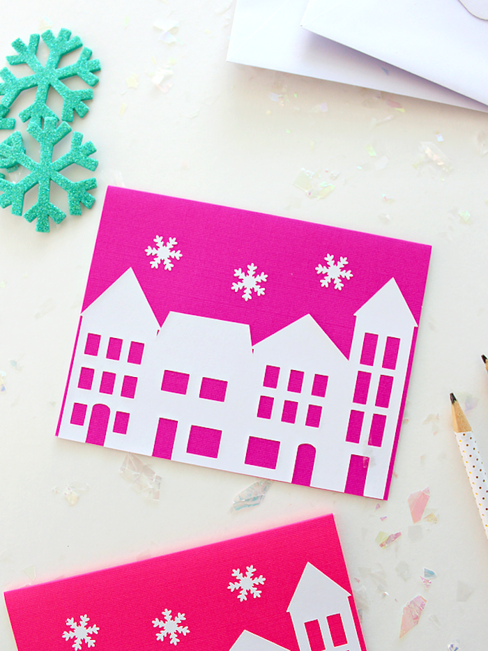Weihnachtskarten mit Kindern basteln, rosa Grund, weiße Häuser und Schneeflocken