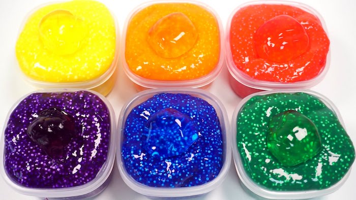 Schleim in Regenbogenfarben, in sechs Plastik Schüsseln, kräftige Farben