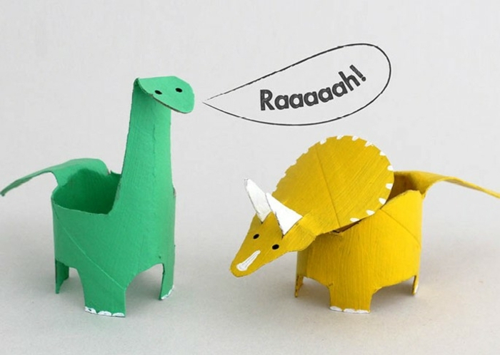 zwei Dinosaurier, einen gelben und einen grünen basteln aus Klopapierrollen
