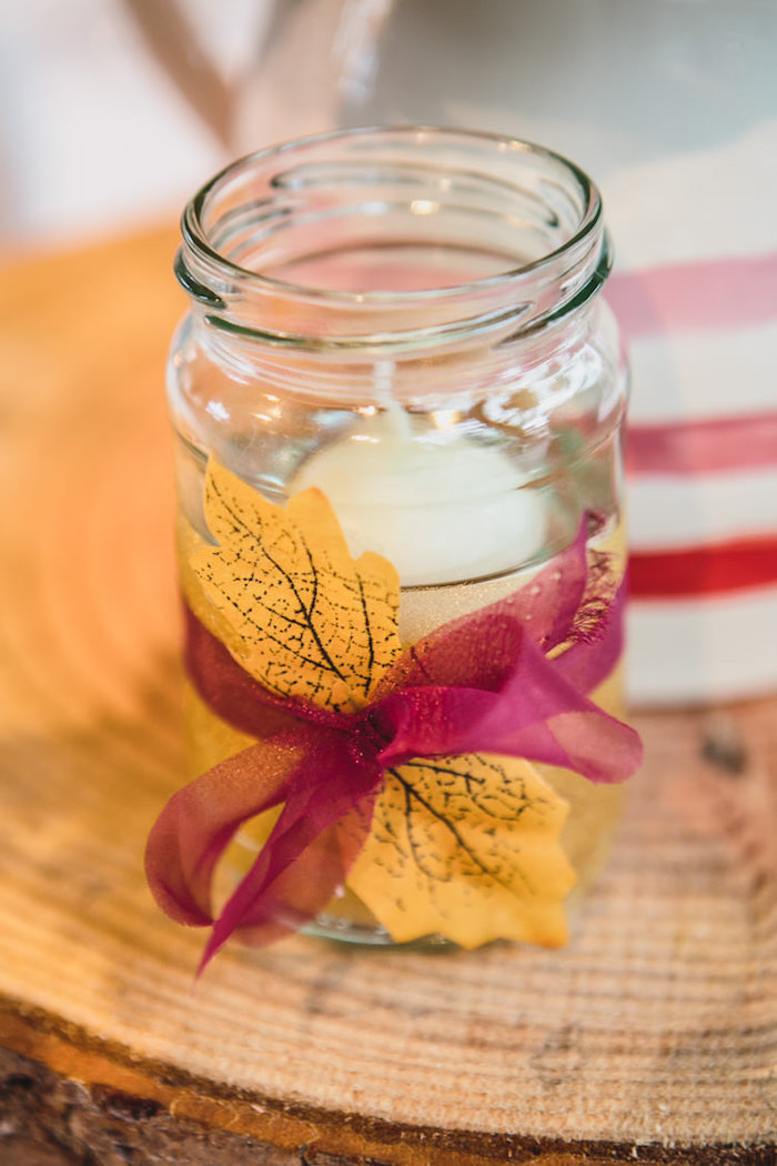 Ideen für herbstliche Hochzeitsdekroation, Einmachglas mit Herbstblättern und roter Schleife dekoriert, weiße Duftkerze
