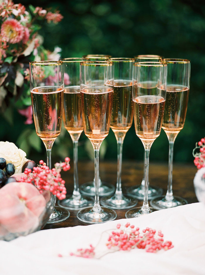 Champagner Gläser aus Kristall mit goldenem Rand, Schüssel voll mit Früchten