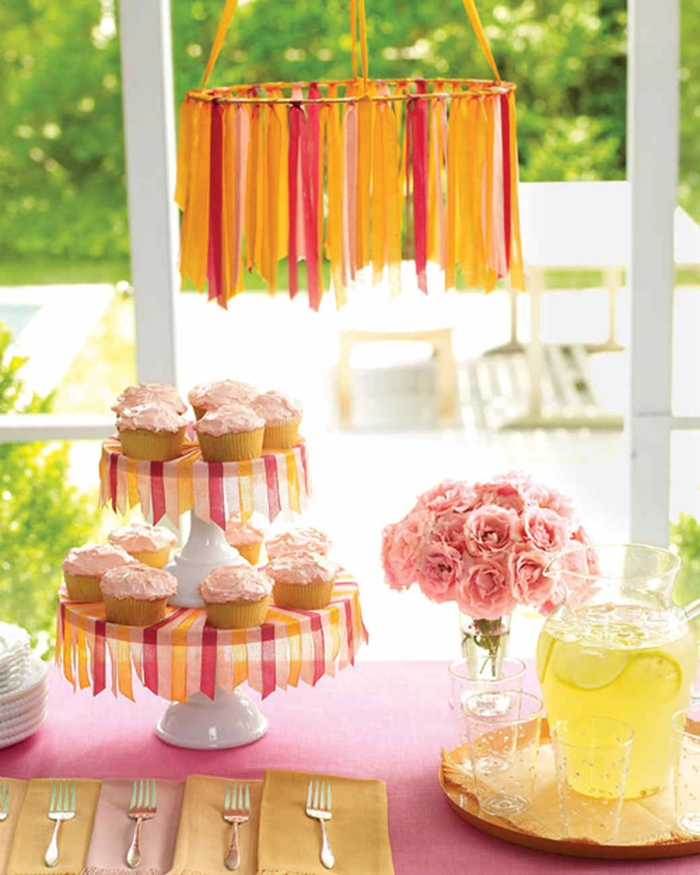 Babyparty für Mädchen, Ständer mit Cupcakes, rosa Blumenstrauß, eine Kanne Limo