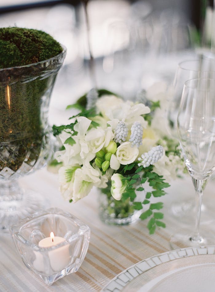 Stilvolle Tischdeko für Hochzeit, weiße Blumen und kleine Duftkerzen, Moos in Vase