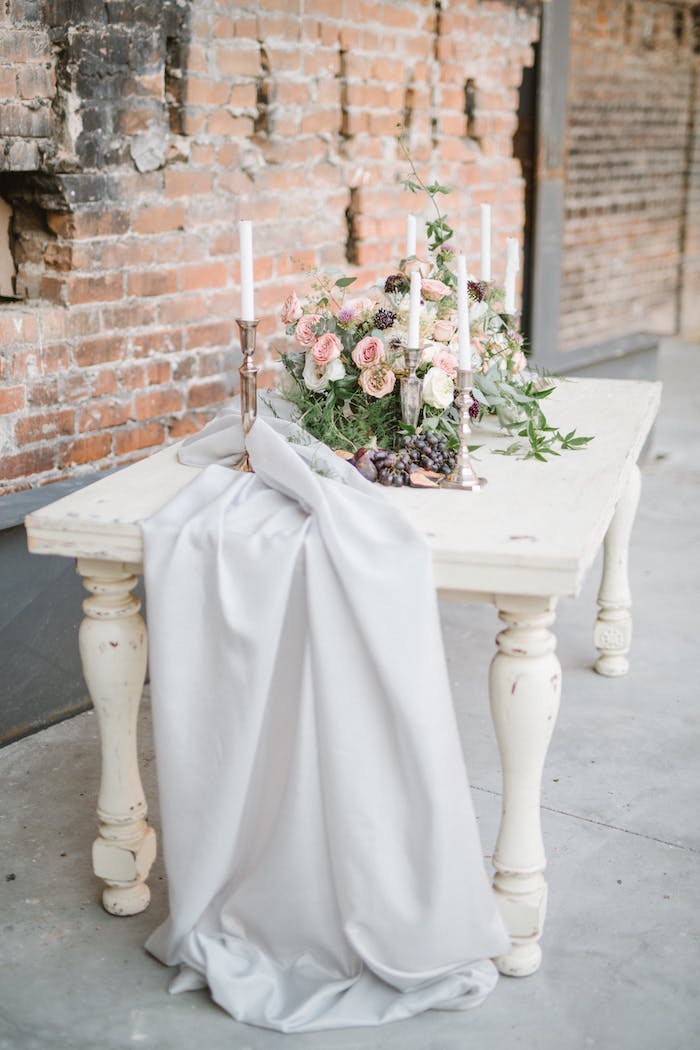 Idee für Tischdeko in Landhausstil, weißer Tisch mit Altersspuren, viele Blumen und weiße Kerzen