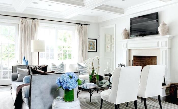 dekoideen wohnzimmer, blaue hortensien, viel licht, kamin in retro stil, weiße sessel