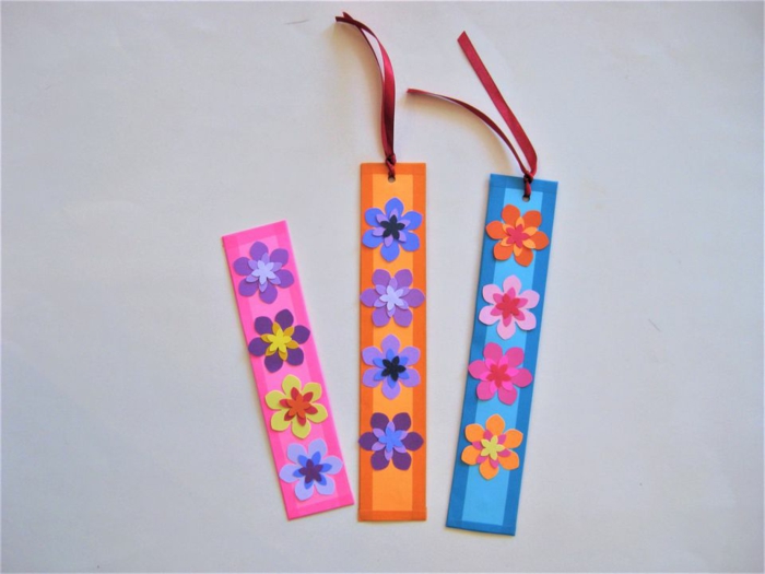 rosa, orange und blaues Lesezeichen basteln, kleine bunte Blümchen und Schleifen als Dekoration