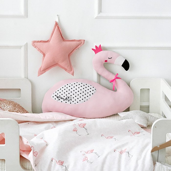 ein kinderzimmer einrichten, flamingo deko, eine pinke große flamingo mit einer violetten krone und ein stern und ein weißes bett mit einer weißen decke mit kleinen pinken flamingos 