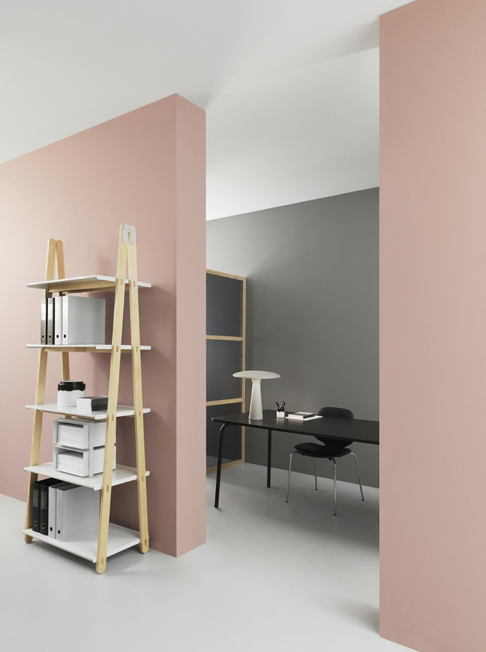 ein Büro mit minimalistischem Design mit altrosa Wandfarbe, ein Regal für die Papiere