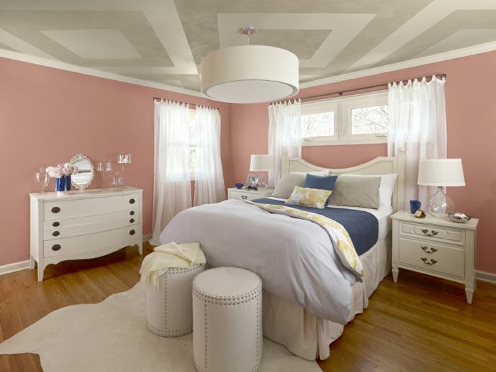 altrosa Wandfarbe im Schlafzimmer, weiße Gardinen, weißes Bettwäsche und weiße Hocker
