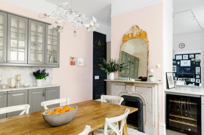 eine moderne Küche mit vintage Spiegel, graue Regale, rosa mischen, langer Tisch aus Holz