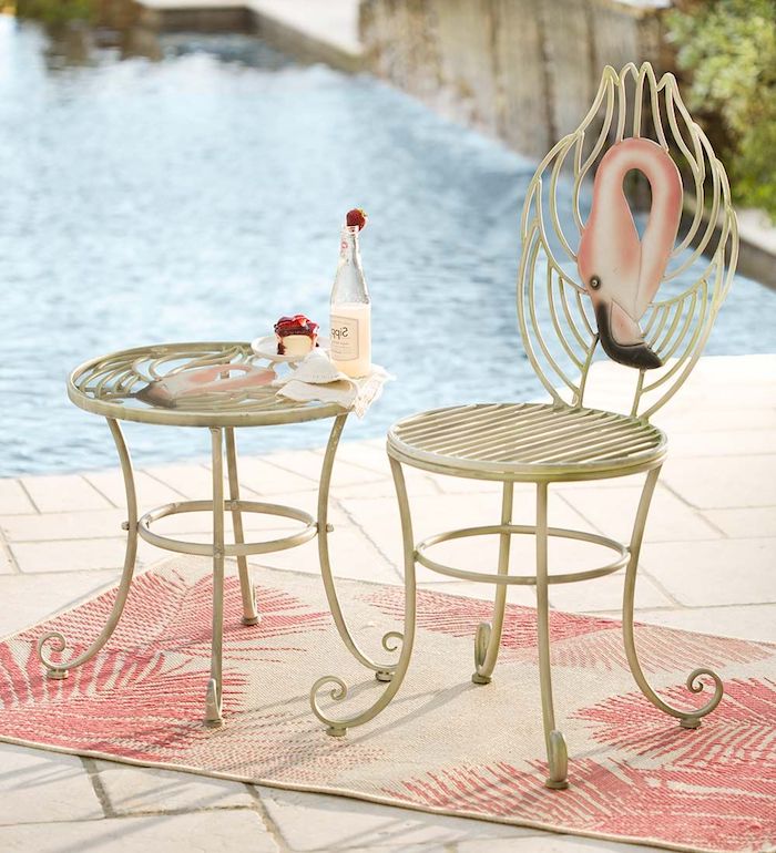 ein teppich mit pinken blättern und ein schwimmpool und ein weißer stuhl mit einer pinken deko flamingo, ein tisch mit einer flasche aus glas