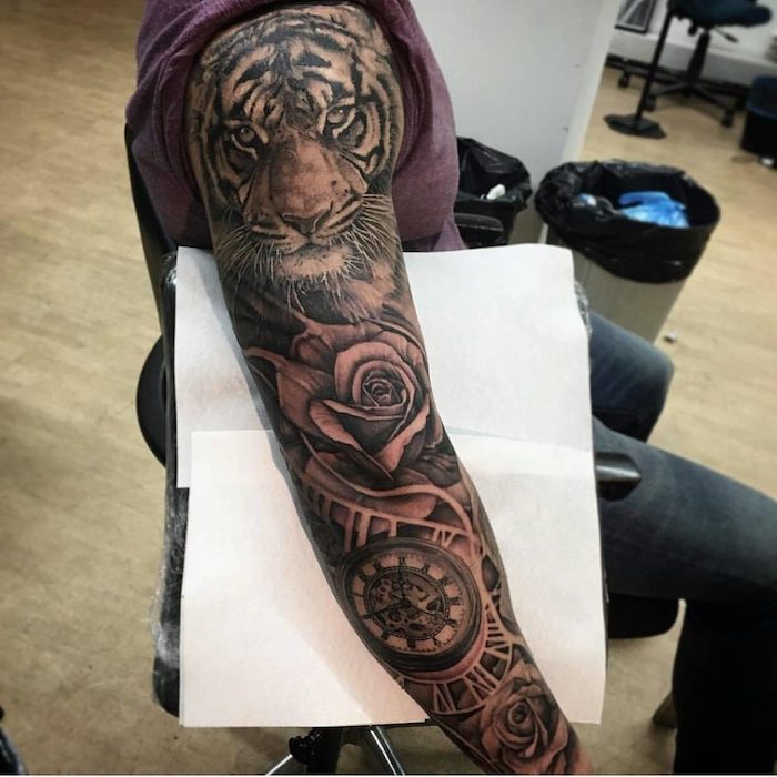 ein stuhl und ein mann mit einer hand mit einem großen schwarzen tattoo arm mit einem tiger und uhren und großen schwarzen rosen