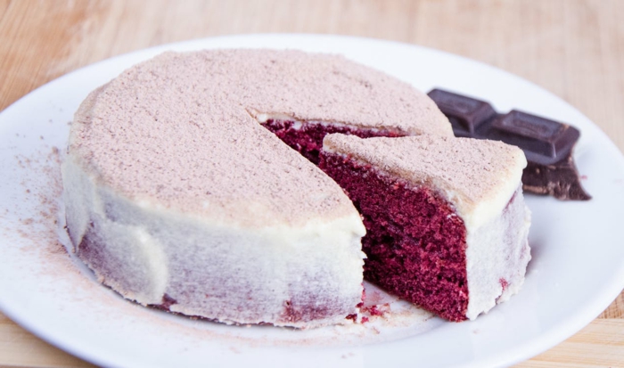 rosa Kuchen mit rotem Inneren, rosa und weiße Creme, mit Schokolade serviert, ausgefallene Torten