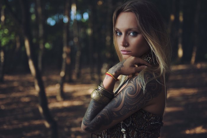 ein wald mit bäumen und eine junge frau mit armband und mit einem großen schwarzen arm tattoo, tattoos frauen ideen