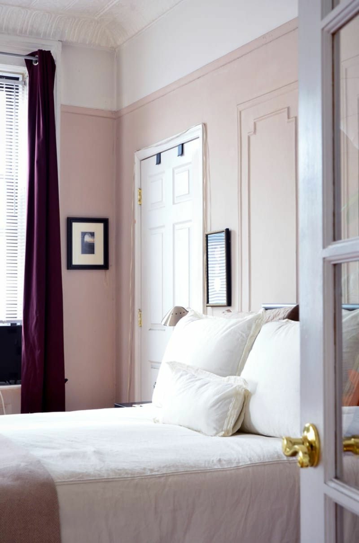 Altrosa Farbe in dem Schlafzimmer, weiße Kissen, lila Vorhänge, zwei Bilder, Rollos am Fenster