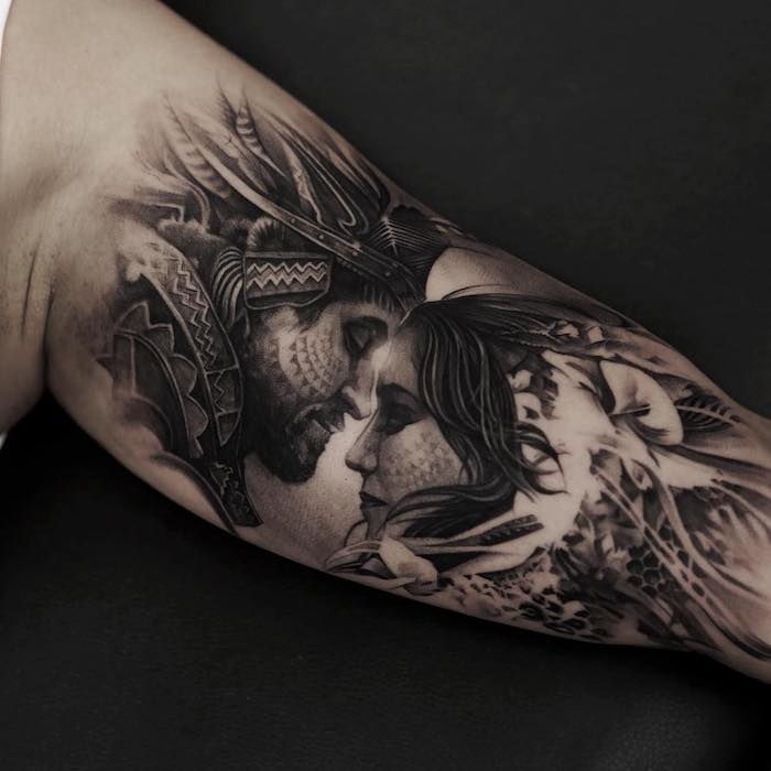ein mann mit einer hand mit einem großen schwarzen tattoo arm mit zwei indianern mit vielen langen federn, tattoos für paare