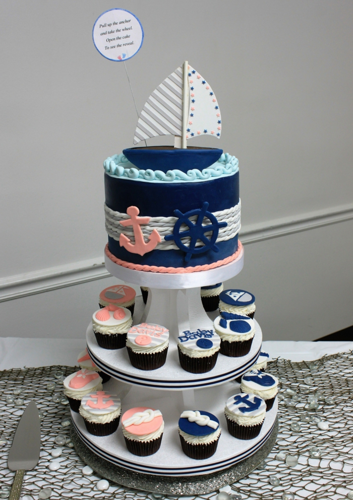 eine Torte und Cupcakes, eine graue Decke, blaue Creme und ein Boot, Ideen für Babyparty