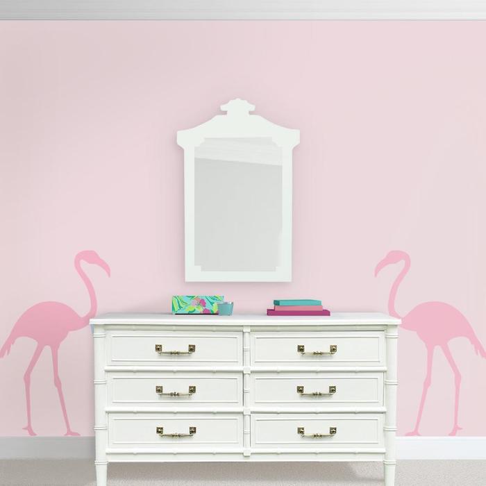eine pine flamingo tapete und ein weißer spiegel, eine pinke wand mit zwei großen pinken flamingos mit pinken federn