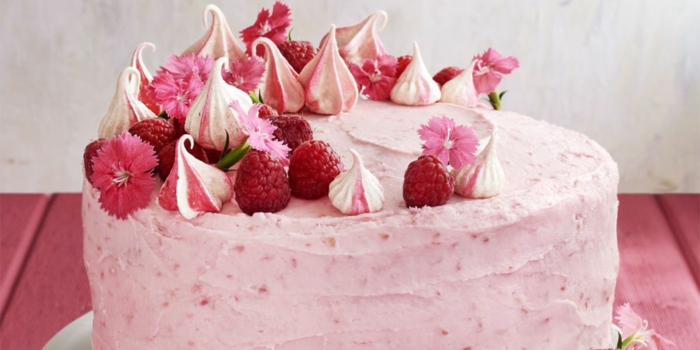 Torte mit rosa Glasur, Himbeere und kleine rosa Blümchen als Deko, einfache Torten