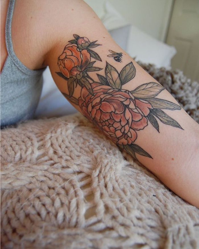 eine hand mit einem großen tattoo mit vielen roten rosen mit vielen grünen bläettern, rosen tattoos ideen für frauen