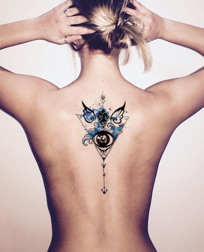eine junge frau mit einem rücken tattoo mit einer schwarzen auge und mit zwei kleinen schwarzen flügeln und mit blauen wellen
